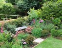 A bench surrounded by masses of summer flower